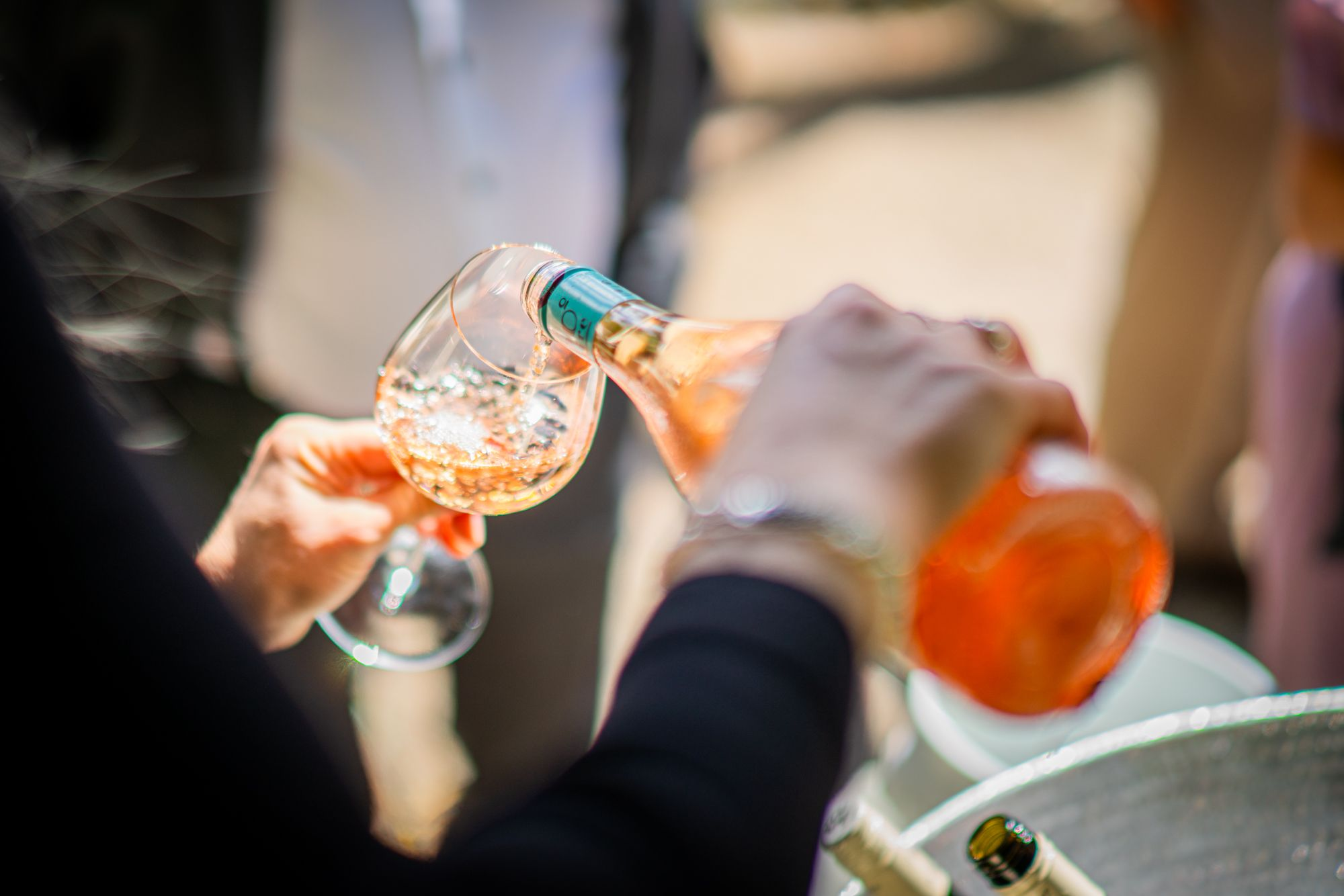 Rosé skænkes i glas på terrassen